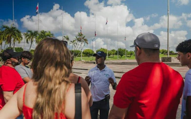 Tour guide explaining to a group at a monument in Santo Domingo during a day tour from Punta Cana.