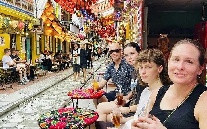 People enjoying drinks at a café along Hanoi's Train Street in the Old Quarter.