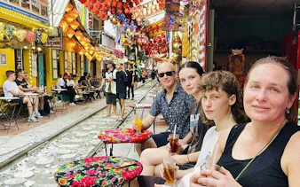 People enjoying drinks at a café along Hanoi's Train Street in the Old Quarter.