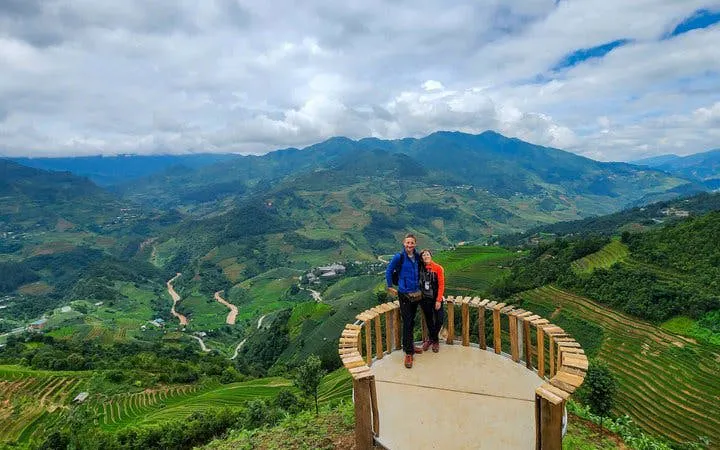 Mu Cang Chai rice terraces view with tourists on a motorbike tour platform.