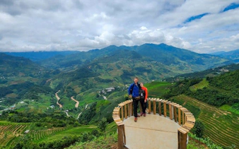 Mu Cang Chai rice terraces view with tourists on a motorbike tour platform.