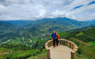 Mu Cang Chai rice terraces view with tourists on a motorbike tour platform.