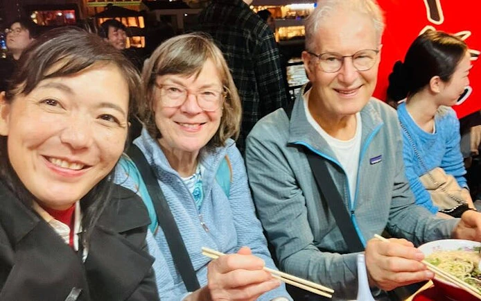 Tourists enjoying ramen at a Nakasu food stall in Fukuoka.