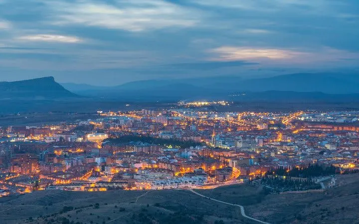 Soria cityscape at dusk, view from above, highlighting illuminated streets for self-guided walking tour.