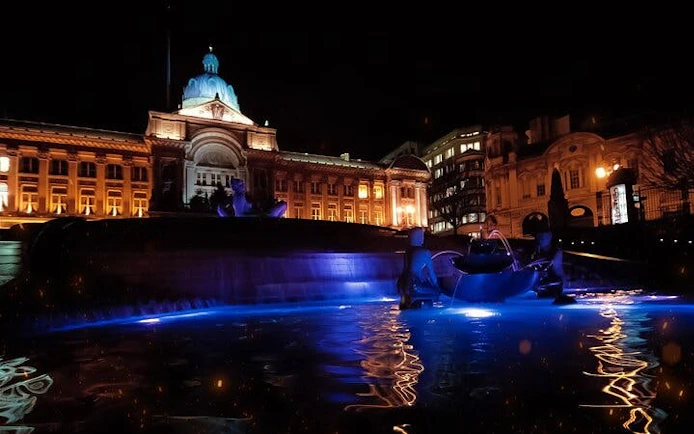 Birmingham Town Hall illuminated at night with reflections in a fountain, part of a haunted city exploration game.