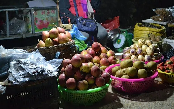 Market stall with baskets of fresh fruits in Sapa during a guided culinary tour.