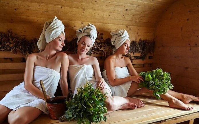 Women relaxing in a traditional Moroccan hammam with herbal treatments in Marrakech.