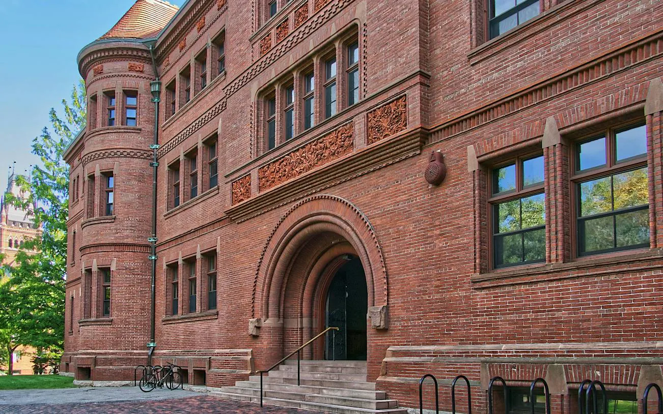 Harvard Yard brick building with arched entrance, part of self-guided audio walk in Boston.