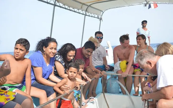 Tourists on a glass boat during a sea trip in Sharm El Sheikh, preparing for parasailing.