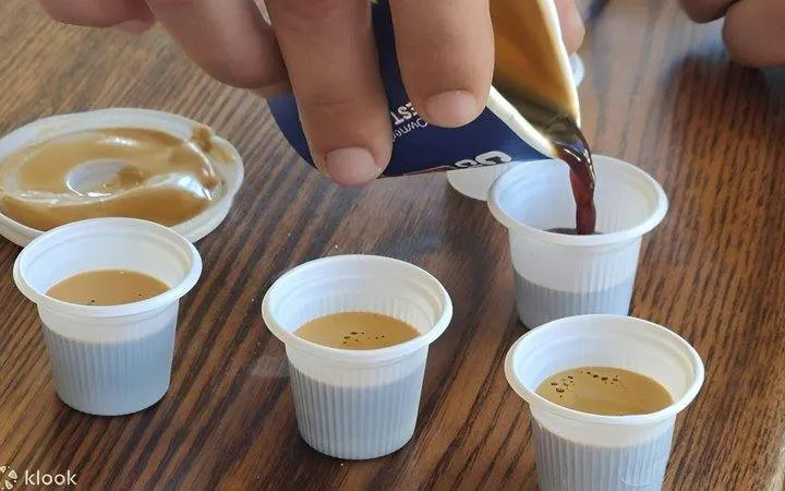Pouring Cuban coffee into small cups during Little Havana walking tour in Miami.