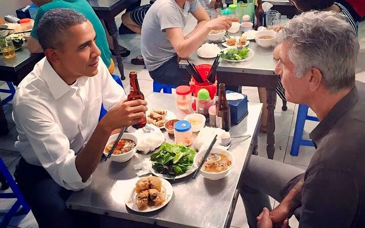 Participants enjoying Bun Cha at a Vietnamese cooking class in a casual, family-style setting.