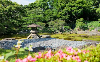 Japanese garden with stone lantern and pond at Tokyo Imperial Palace.