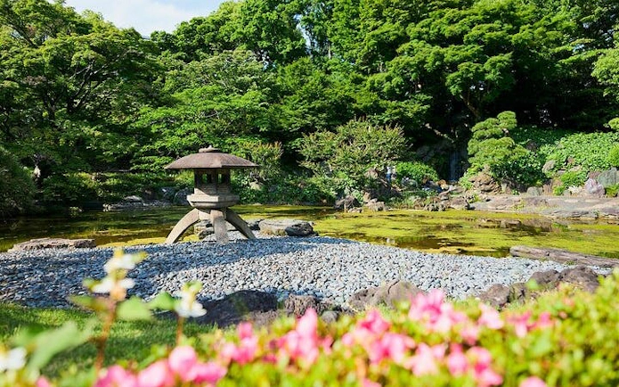 Japanese garden with stone lantern and pond at Tokyo Imperial Palace.