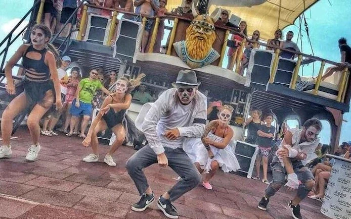 Dancers in costume performing on a pirate-themed boat during the GONSTER Deluxe Pirate Boat Trip from Kemer.