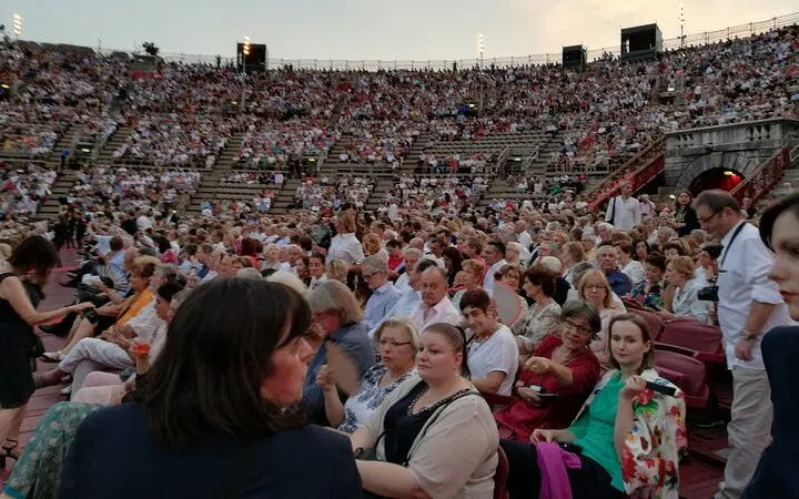 Audience seated at Arena di Verona for an opera performance during a guided city tour.