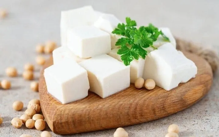 Tofu cubes on a wooden board with soybeans, Sa Pa cooking class.
