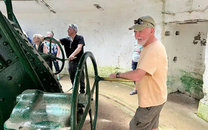 Tourists exploring historic machinery on Auckland City Half Day Sightseeing Tour.