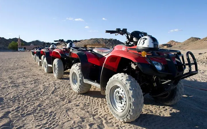 Quad bikes lined up on desert terrain for safari tour in Hurghada.