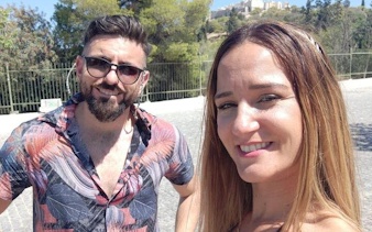 Couple enjoying Athens city exploration with Acropolis in the background.