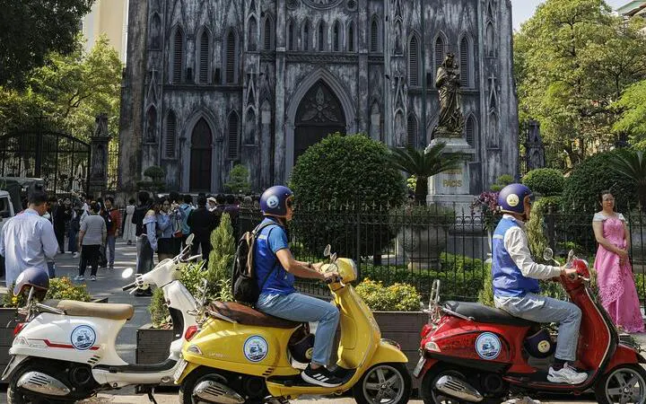Vespa riders in front of St. Joseph's Cathedral, Hanoi, during a half-day tour.