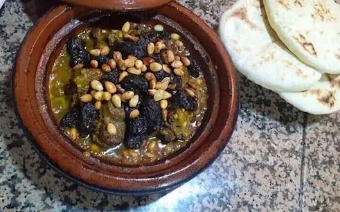 Moroccan tagine with prunes and pine nuts served with flatbread during Essaouira city tour cooking class.