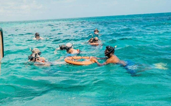 Snorkelers in turquoise water during catamaran cruise, Punta Cana.