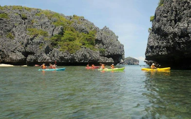 Kayakers exploring limestone cliffs at Ang Thong National Marine Park, Koh Samui.