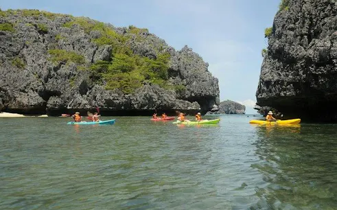 Kayakers exploring limestone cliffs at Ang Thong National Marine Park, Koh Samui.