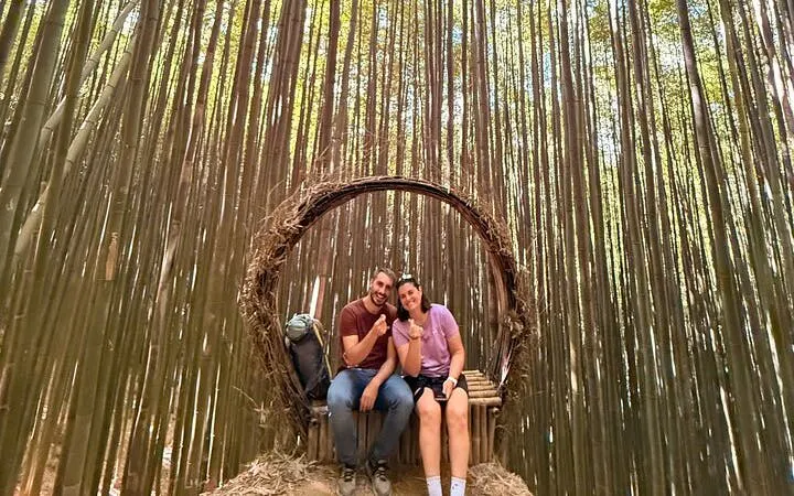 Couple sitting in a bamboo forest on a private car tour from Sapa to Mu Cang Chai rice terraces.