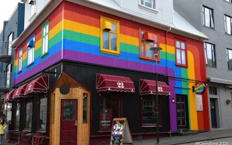 Colorful building with rainbow mural on Reykjavik street, part of guided walking tour through hidden alleys.