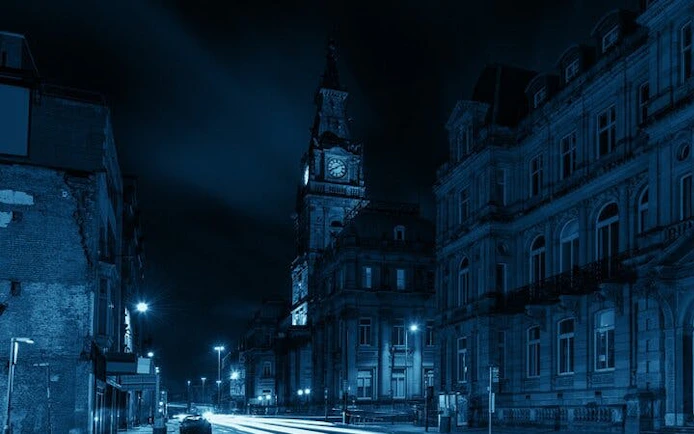 Liverpool street at night with historic clock tower, part of haunted city exploration game.