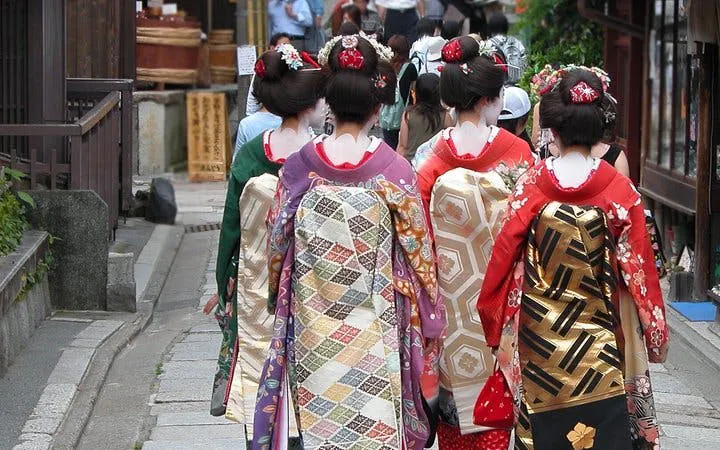 Geisha walking in Kyoto's Gion district, showcasing traditional kimonos.
