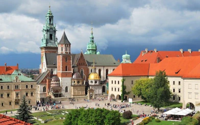 Wawel Castle complex in Krakow with tourists exploring the courtyard.