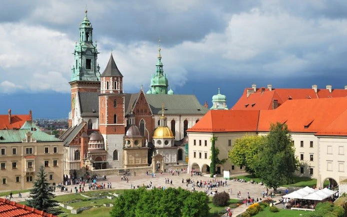 Wawel Castle complex in Krakow with tourists exploring the courtyard.