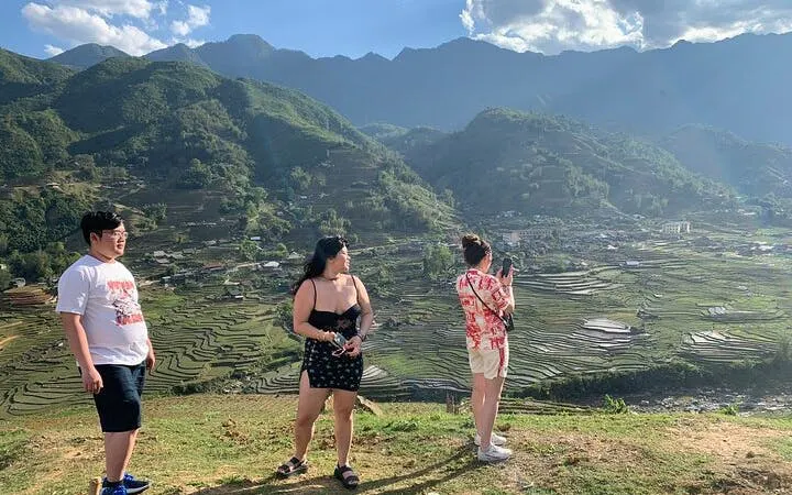 Tourists overlooking terraced rice fields in Sapa, Vietnam during a guided motorbike tour.