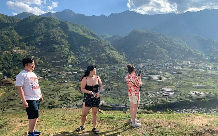 Tourists overlooking terraced rice fields in Sapa, Vietnam during a guided motorbike tour.