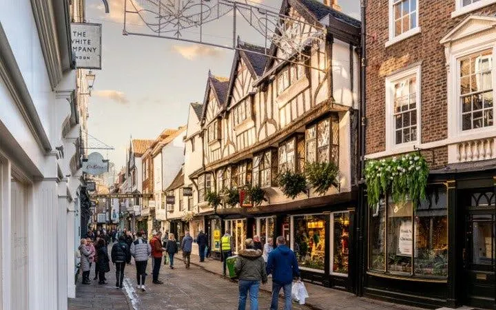 York street with historic buildings and people walking, featured in self-guided mobile app tour.