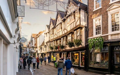 York street with historic buildings and people walking, featured in self-guided mobile app tour.