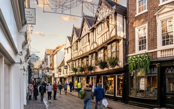 York street with historic buildings and people walking, featured in self-guided mobile app tour.