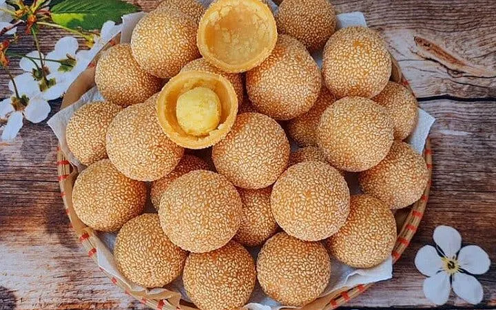 Sesame balls on a wooden table, part of Sapa food tour culinary experience.