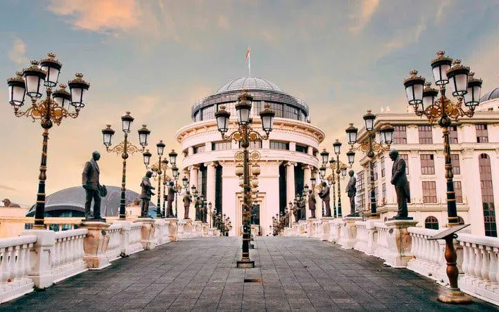Skopje bridge with statues leading to the Archaeological Museum, featured in self-guided walking tour.