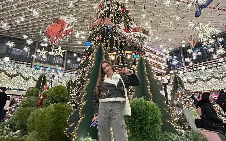 Visitor posing in front of a decorated Christmas tree at Starfield Library, Seoul during Gangnam Walking Tour.