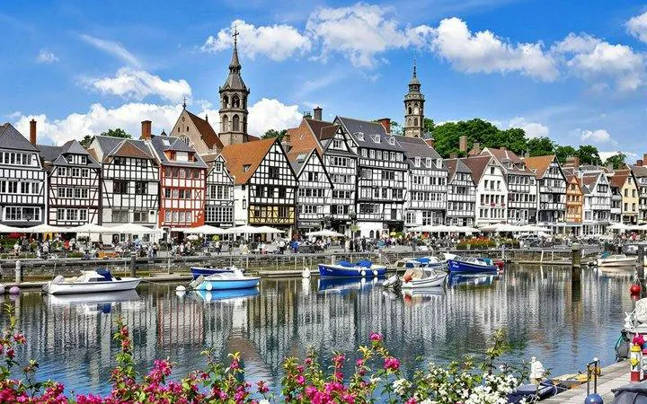 Honfleur harbor with colorful half-timbered buildings and boats, part of Paris day trip to Étretat Cliffs.