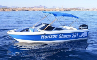 Private speedboat on Sharm El Sheikh shoreline with distant mountains.