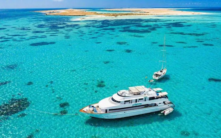 Boat anchored near Tiran Island in clear blue waters, Sharm El-Sheikh snorkeling and diving trip.