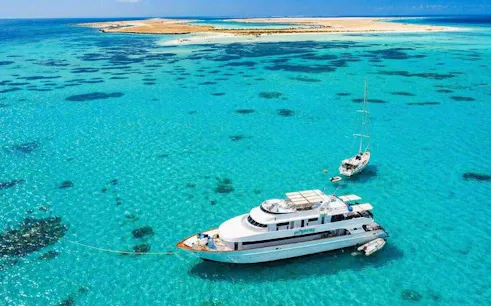 Boat anchored near Tiran Island in clear blue waters, Sharm El-Sheikh snorkeling and diving trip.