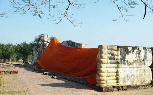 Reclining Buddha statue draped in orange cloth at Ayutthaya, Thailand.