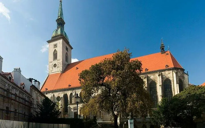 St. Martin's Cathedral in Bratislava with red roof and tall spire, part of self-guided audio tour.