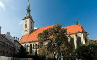 St. Martin's Cathedral in Bratislava with red roof and tall spire, part of self-guided audio tour.