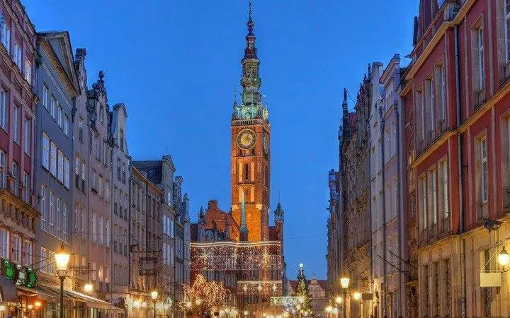 Gdansk Town Hall illuminated at dusk on a self-guided audio walking tour.